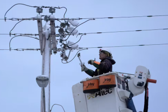 An image of an electrician working on an electrical power line.